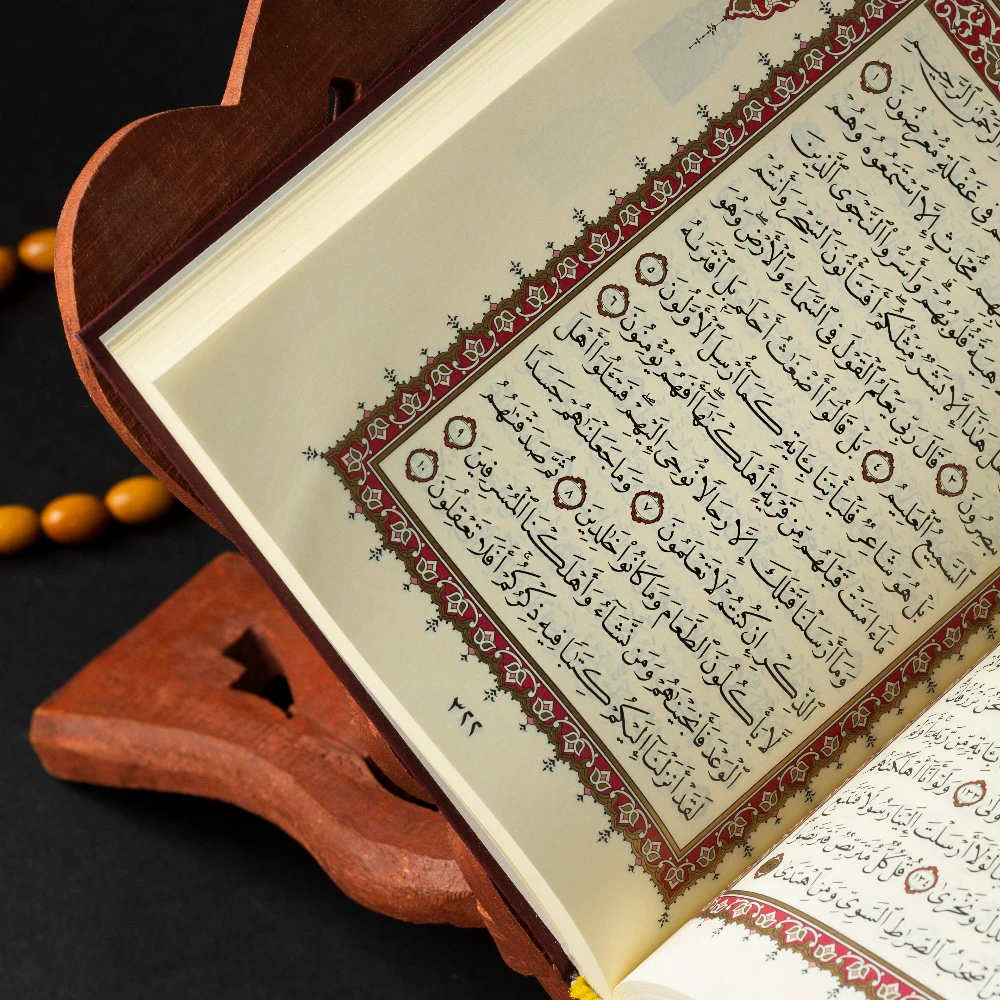 An open Quran resting on a carved wooden stand